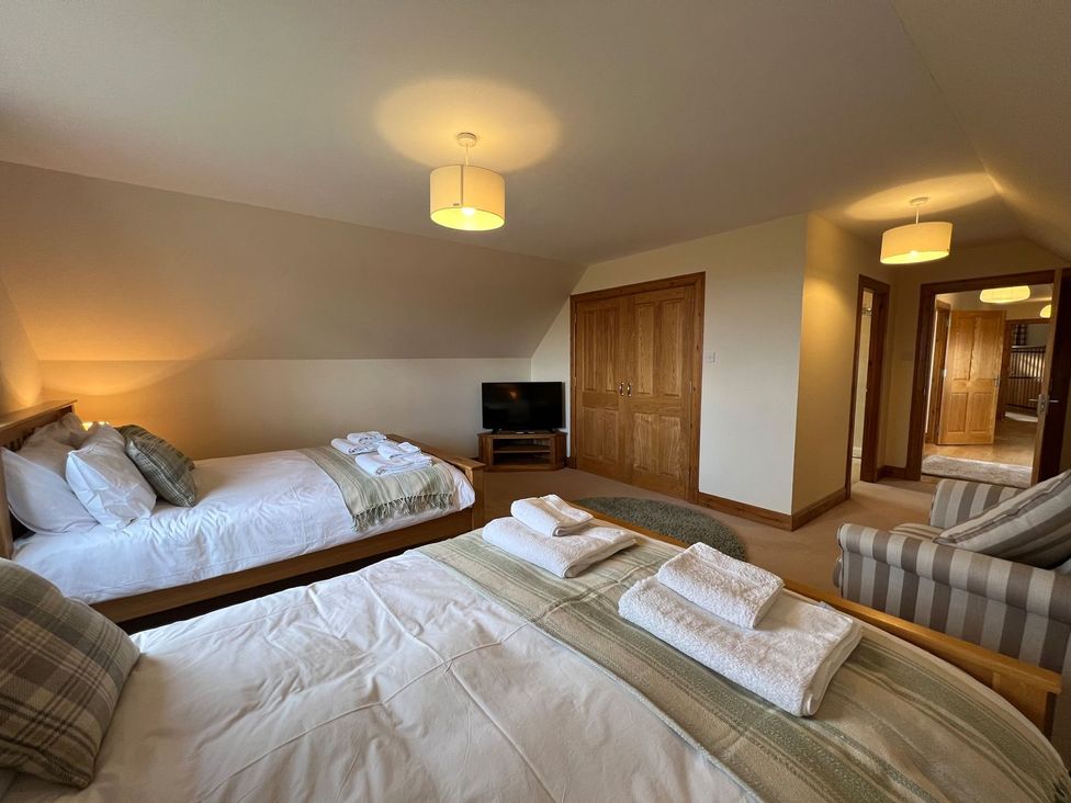 A bedroom with two beds and a television at Airigh nam Fiadh in Creagorry