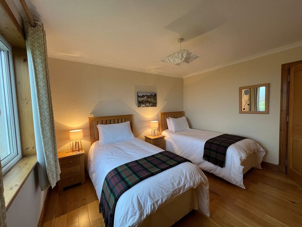 A bedroom with two beds and lamps at Airigh nam Fiadh in Creagorry