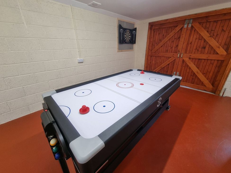 A games room with an air hockey table and dartboard at Airigh nam Fiadh in Creagorry