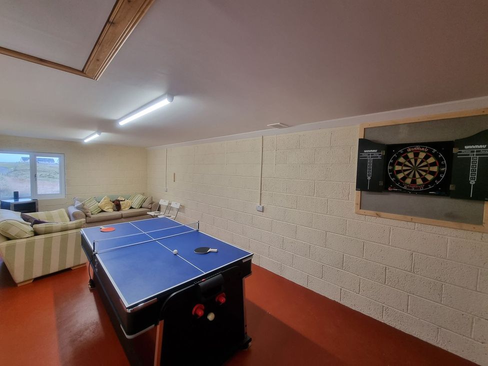 A game room with a table tennis table and a dartboard at Airigh nam Fiadh in Creagorry