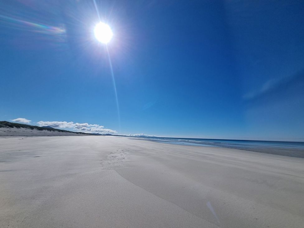 A beach with sand and ocean under a clear sky at Airigh nam Fiadh, Creagorry