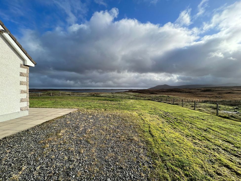 An outdoor view of a house with grass and gravel at Airigh nam Fiadh in Creagorry