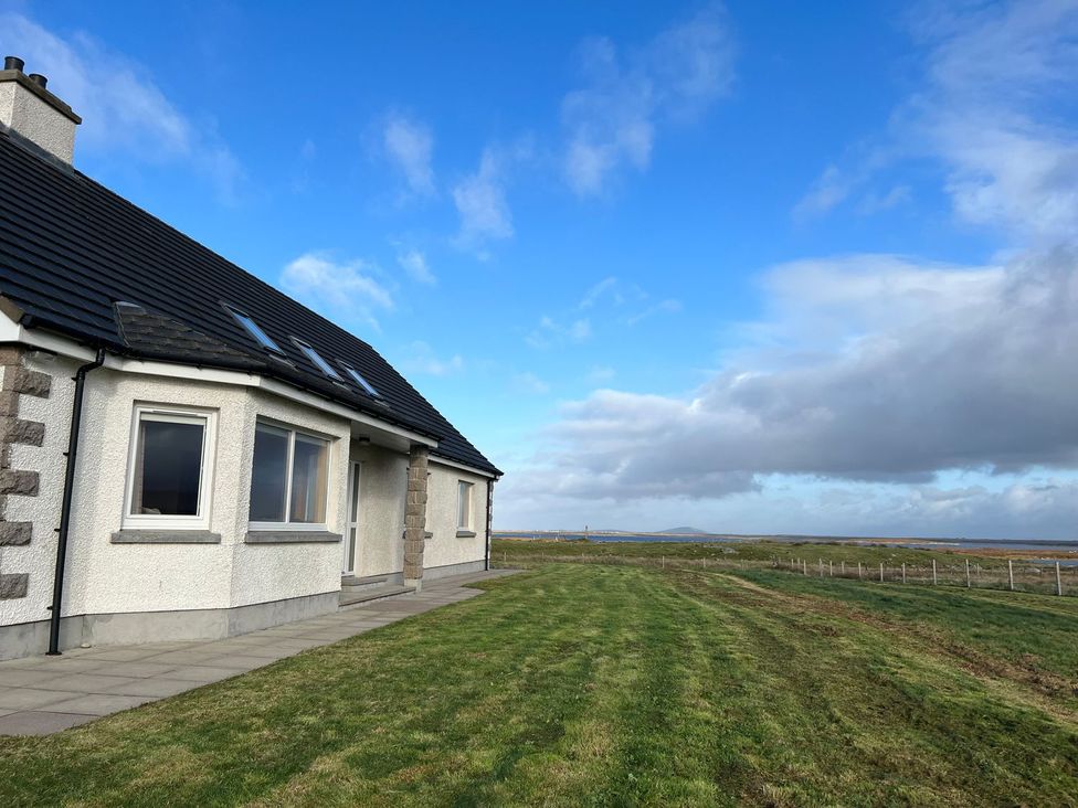 A house with a grassy area and pathway at Airigh nam Fiadh in Creagorry