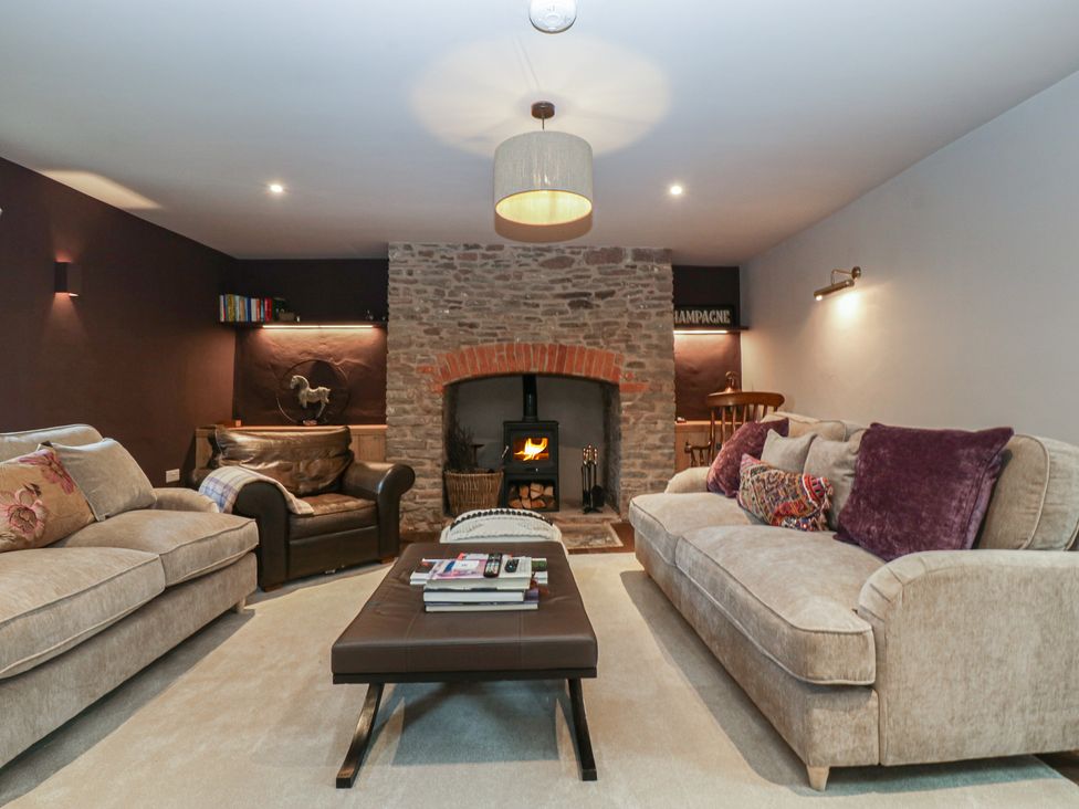 A living room with a fireplace and seating area at 3 bed property