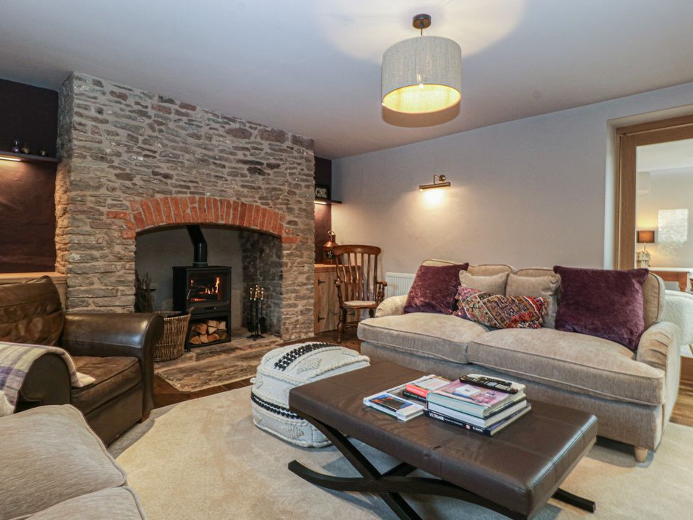 A living room with a stone fireplace and seating at 3 bed property