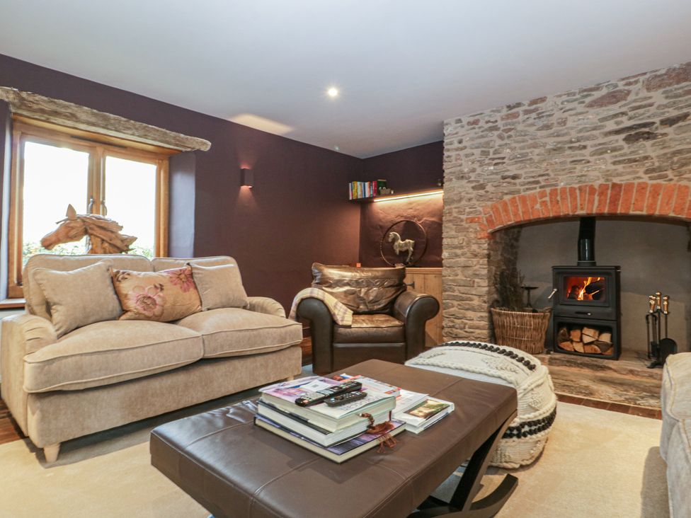 A living room with a wood stove and two sofas at 3 bed property 