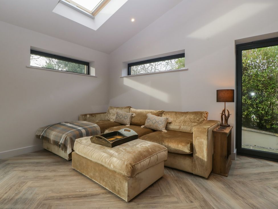 A living room with a sofa and an ottoman at a 3 bed property