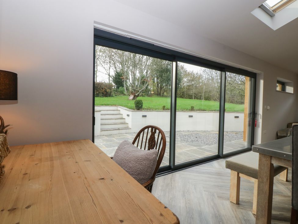 A dining area with a table and chairs overlooking a garden at 3 bed property