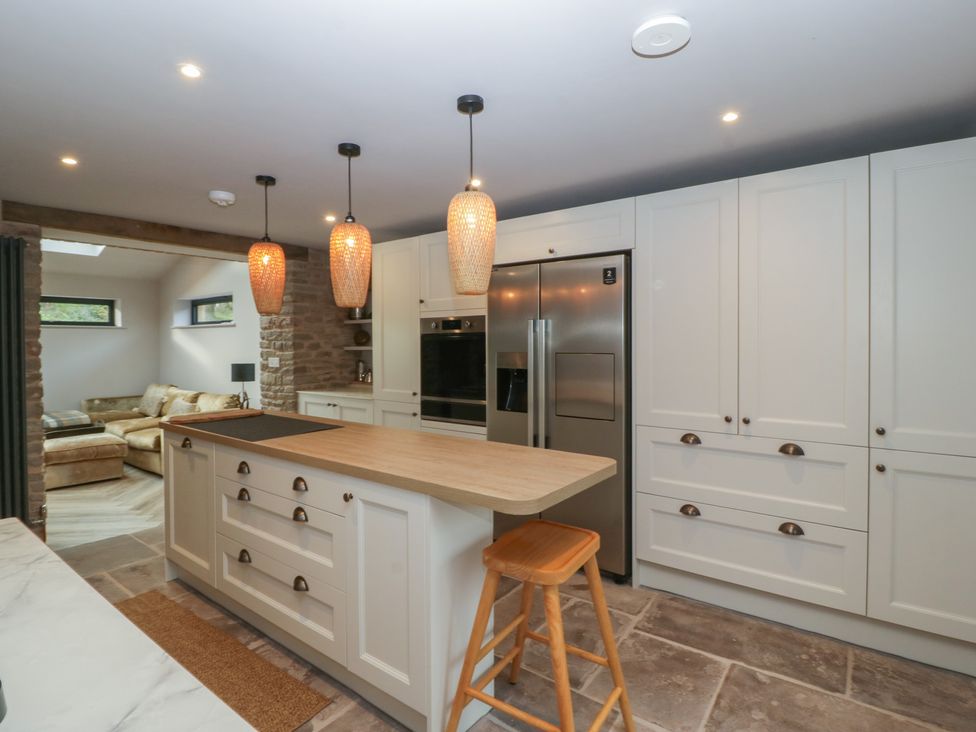 A kitchen with an island and stools at 3 bed property
