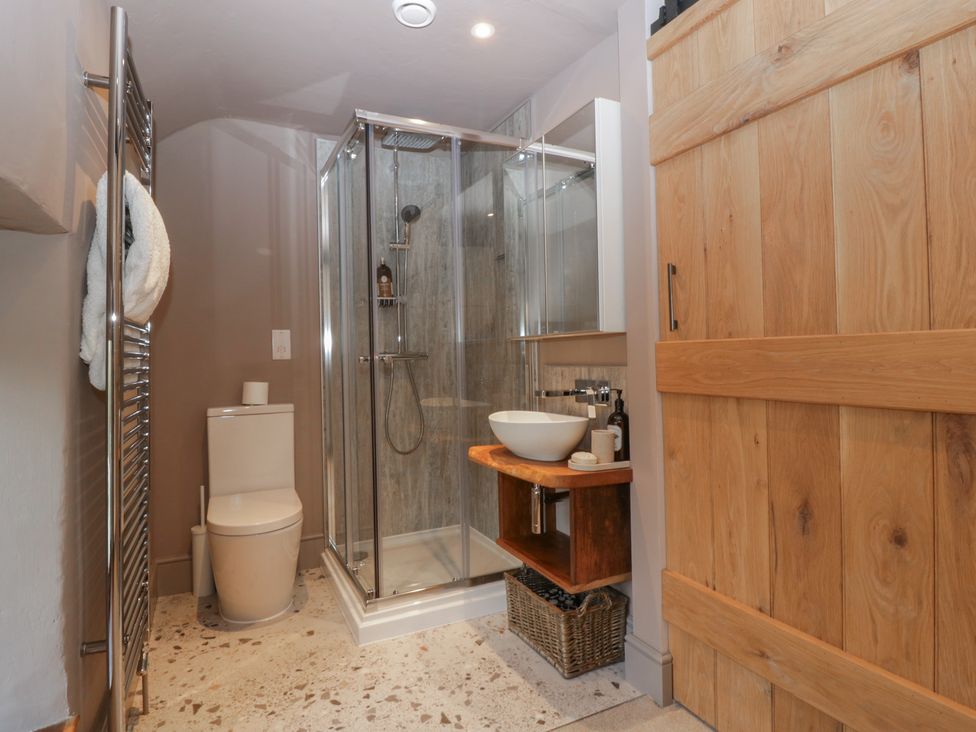 A bathroom with a shower, toilet and sink at a 3 bed property