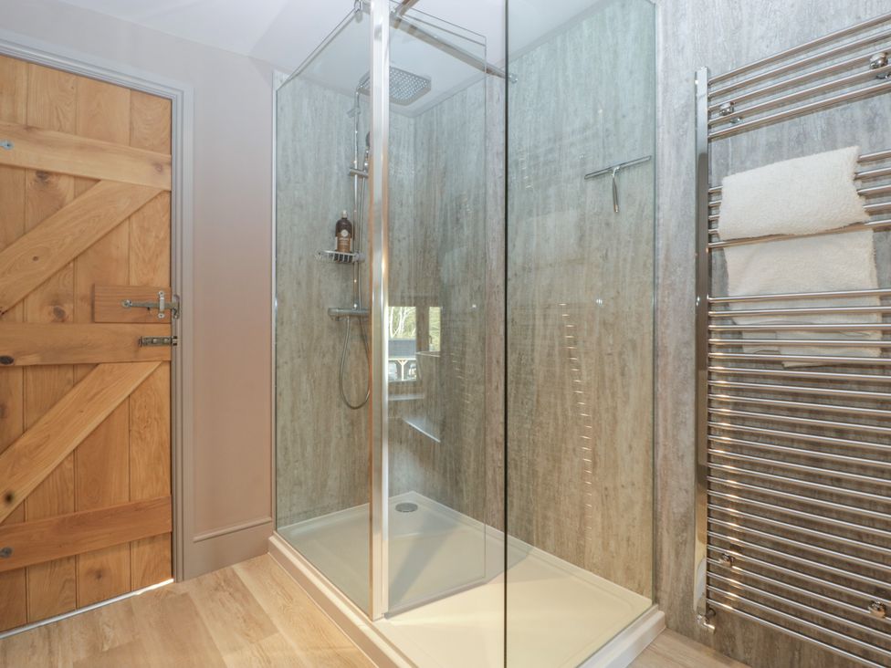 A bathroom with a shower and a towel rack in a 3 bed property