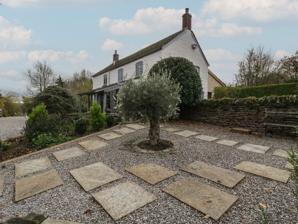 An outdoor view of a house with a garden and stepping stones in a gravel area at a 3 bed property
