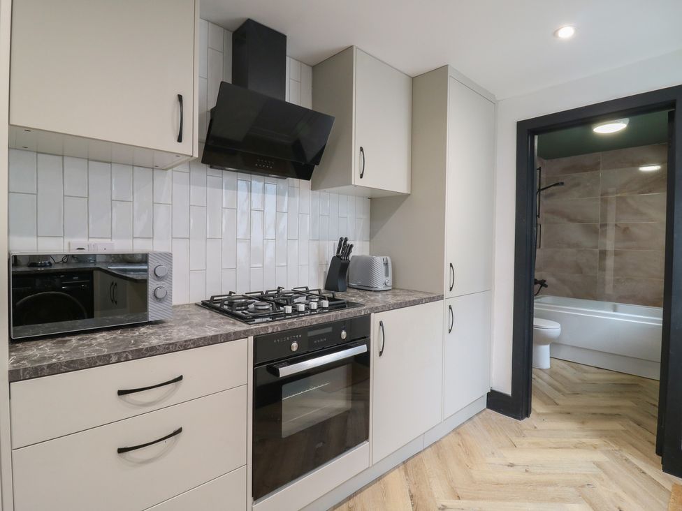 A kitchen with appliances and adjoining bathroom at Seibiant in Ramsgate