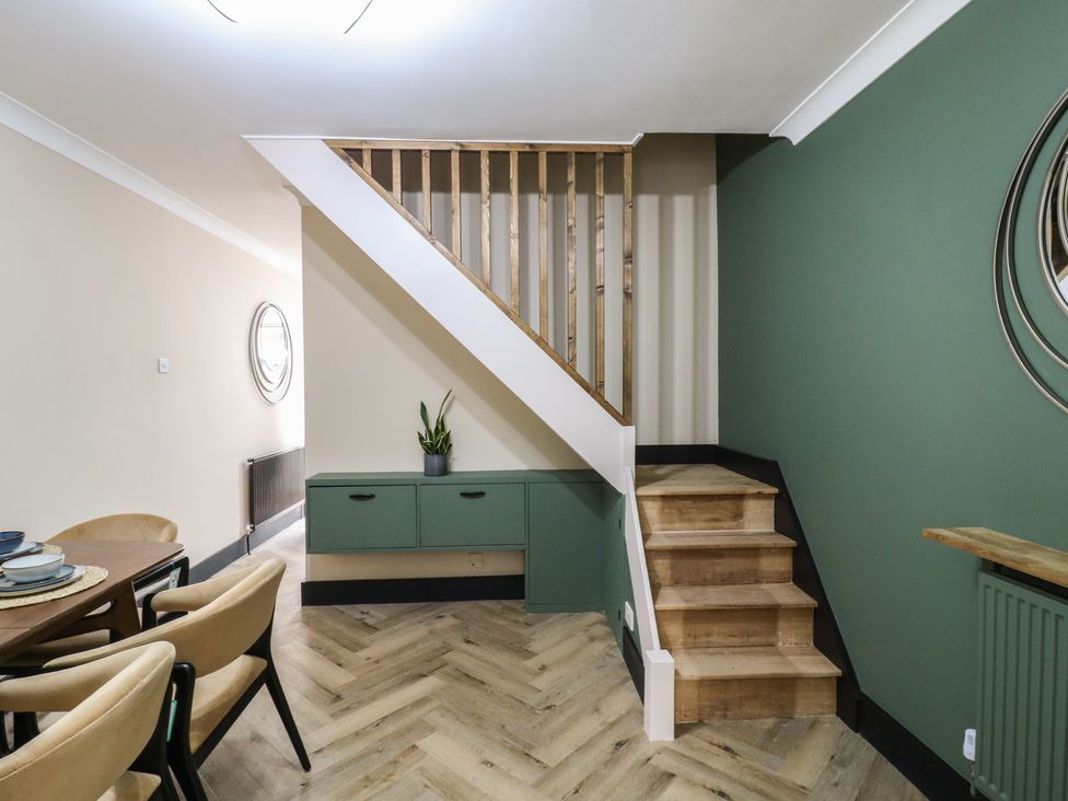 A dining room with a staircase and a cabinet at Seibiant in Ramsgate