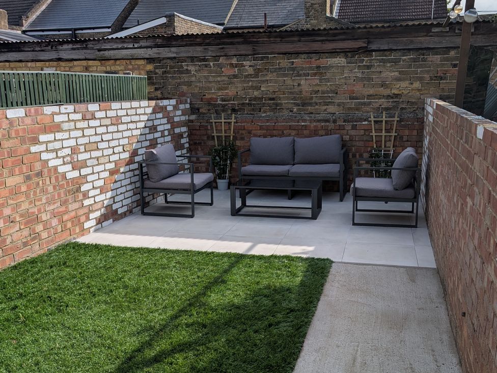 A garden with a sofa and armchairs on a patio at Seibiant in Ramsgate