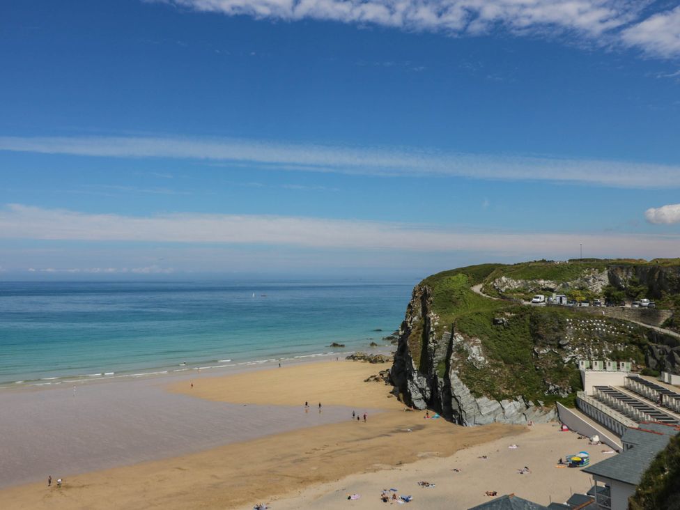 A beach with people and cabins at Higher Tower Road