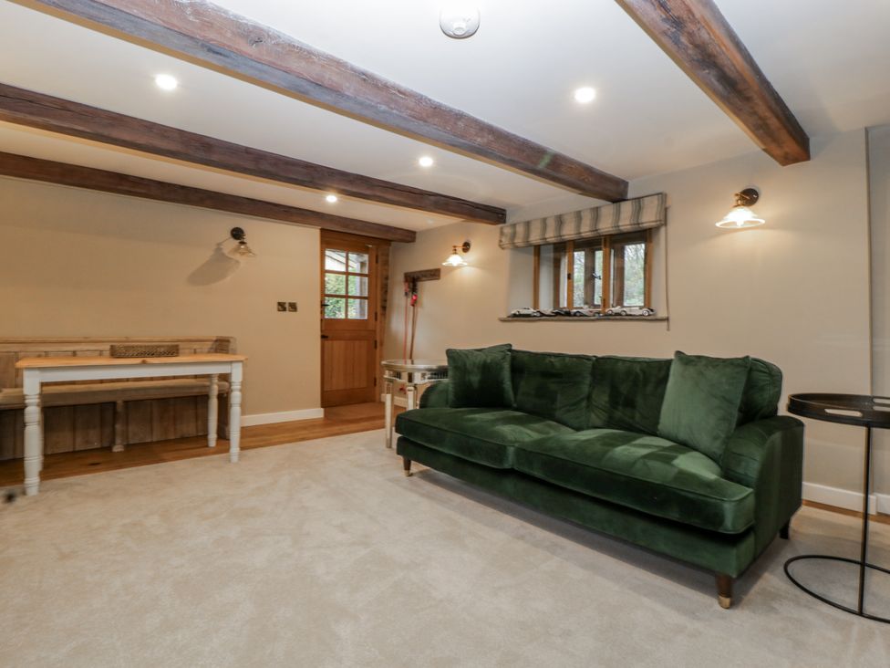 A snug with a green sofa and wooden table at 1 bed property Usk