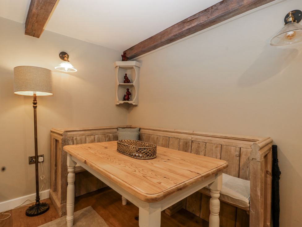 A dining room with a table and bench seating at 1 bed property in Usk