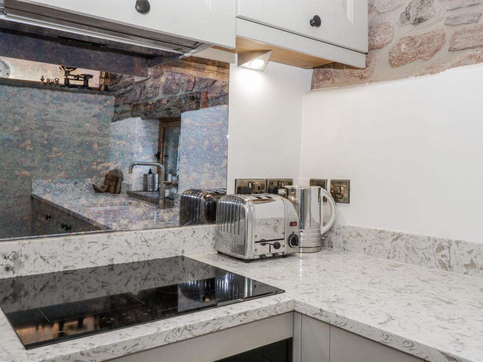 A kitchen with a countertop, toaster, kettle, and stove at 1 bed property Usk