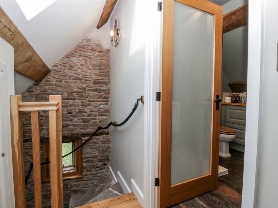A bathroom with a glass door and a toilet in an upstairs area at 1 bed property Usk