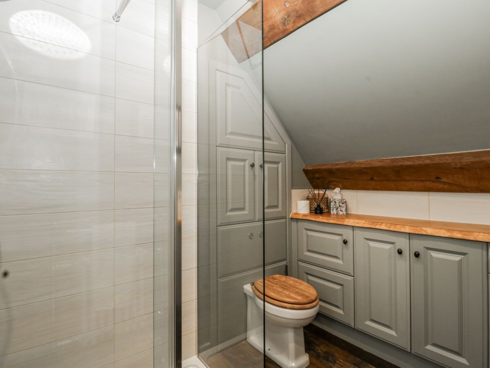 A bathroom with a shower and toilet in a 1 bed property in Usk