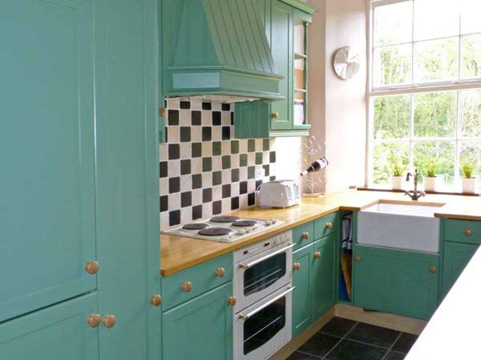 A kitchen with cabinets, stove, sink, and a window at 14 Riverside Walk, Skipton