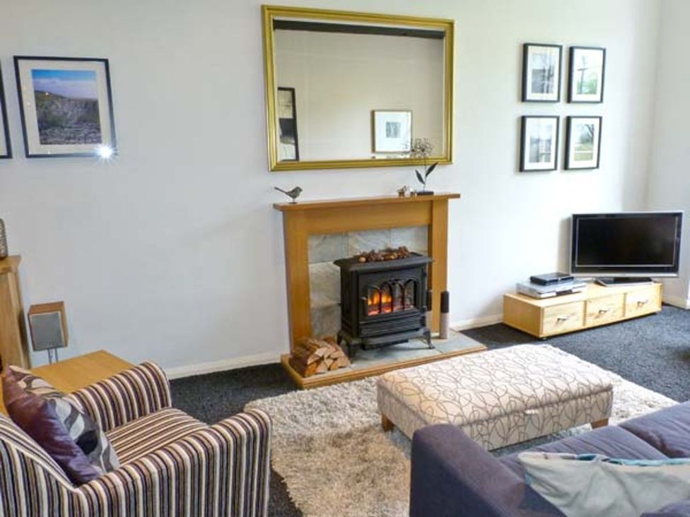 A living room with a fireplace and television at 14 Riverside Walk in Skipton