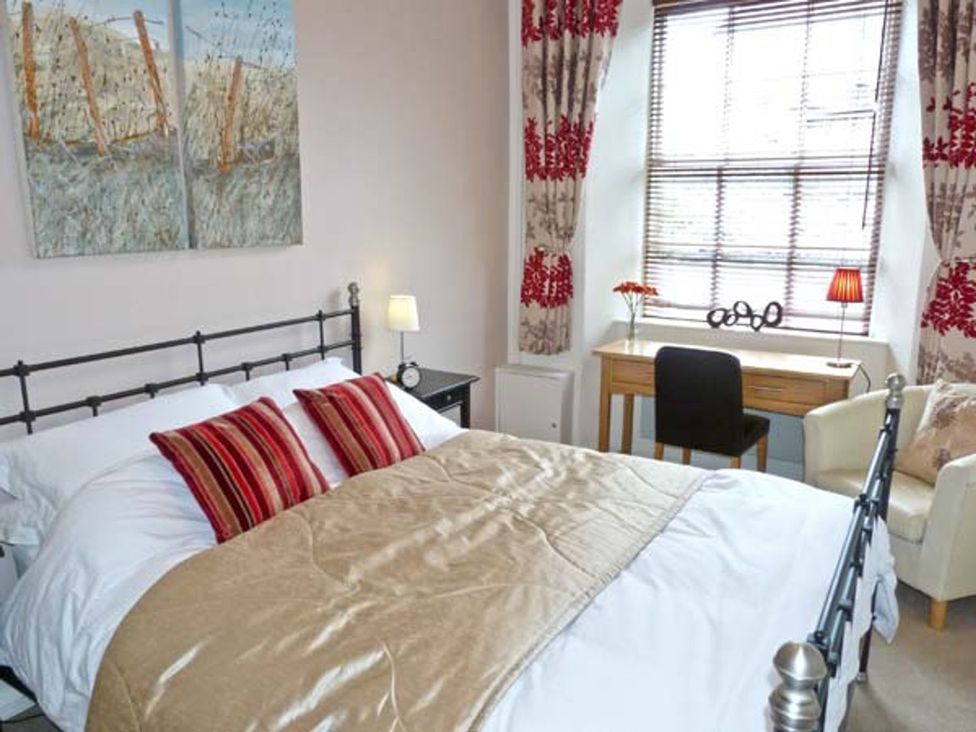 A bedroom with a bed and a desk at 14 Riverside Walk in Skipton