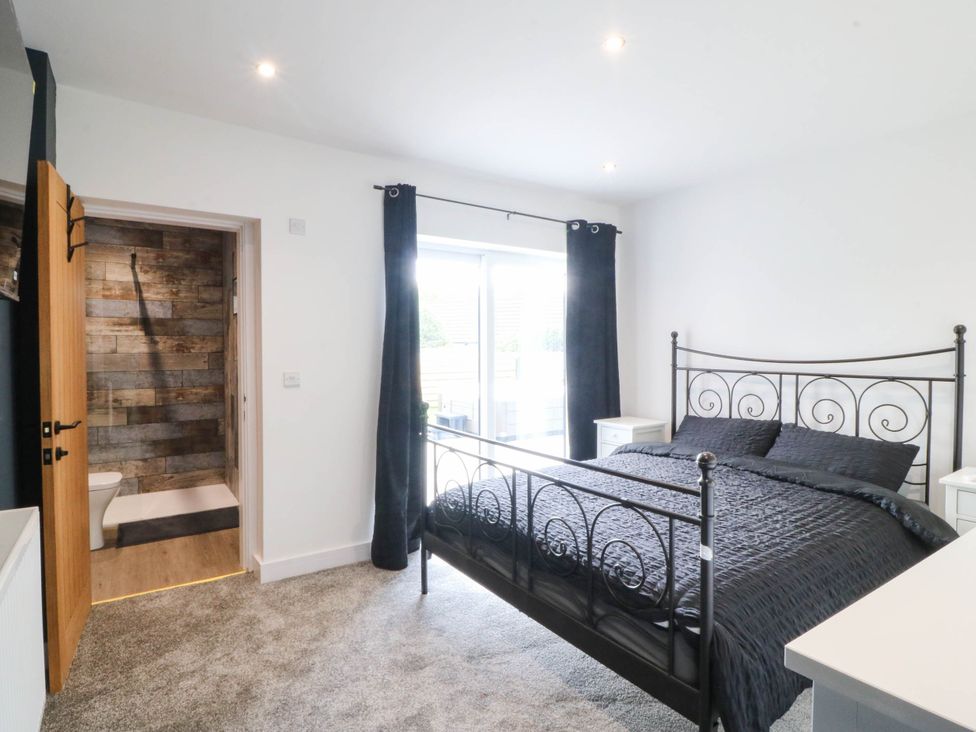 A bedroom with a bed and nightstands at Angorfa in Pentraeth
