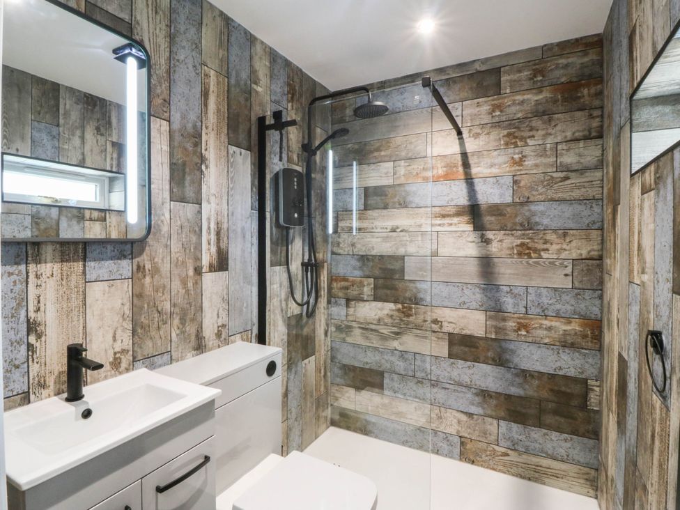 A bathroom with a sink and shower at Angorfa in Pentraeth