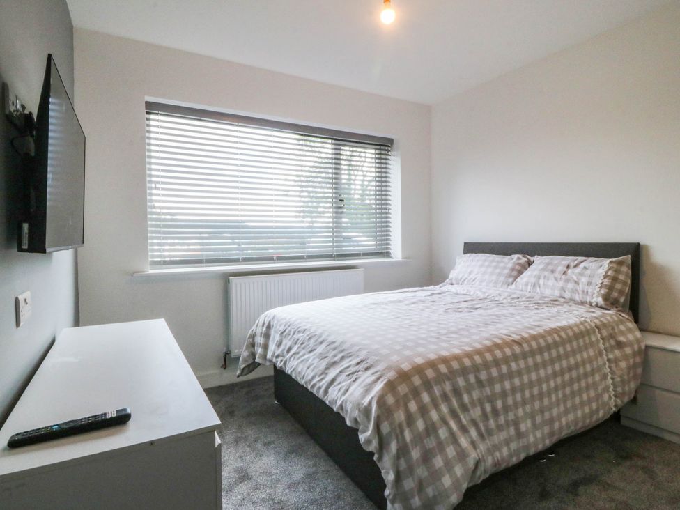 A bedroom with a bed and a television at Angorfa in Pentraeth