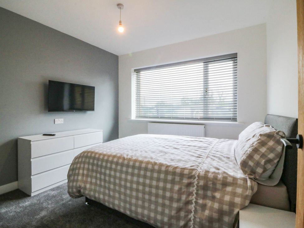 A bedroom with a bed and television at Angorfa in Pentraeth