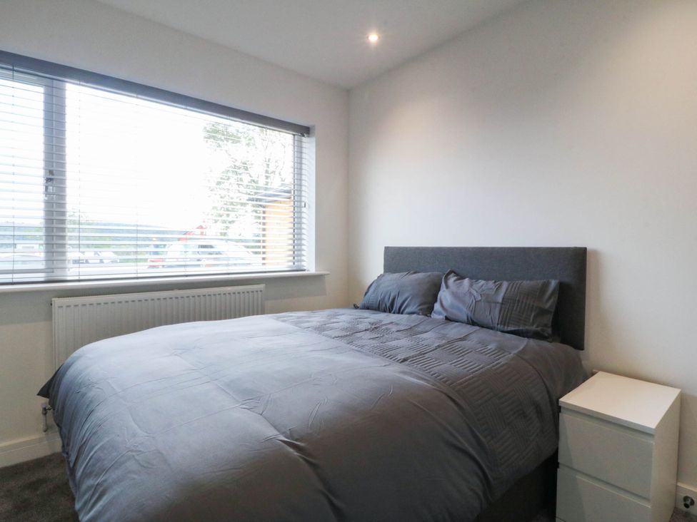 A bedroom with a bed and a window at Angorfa in Pentraeth