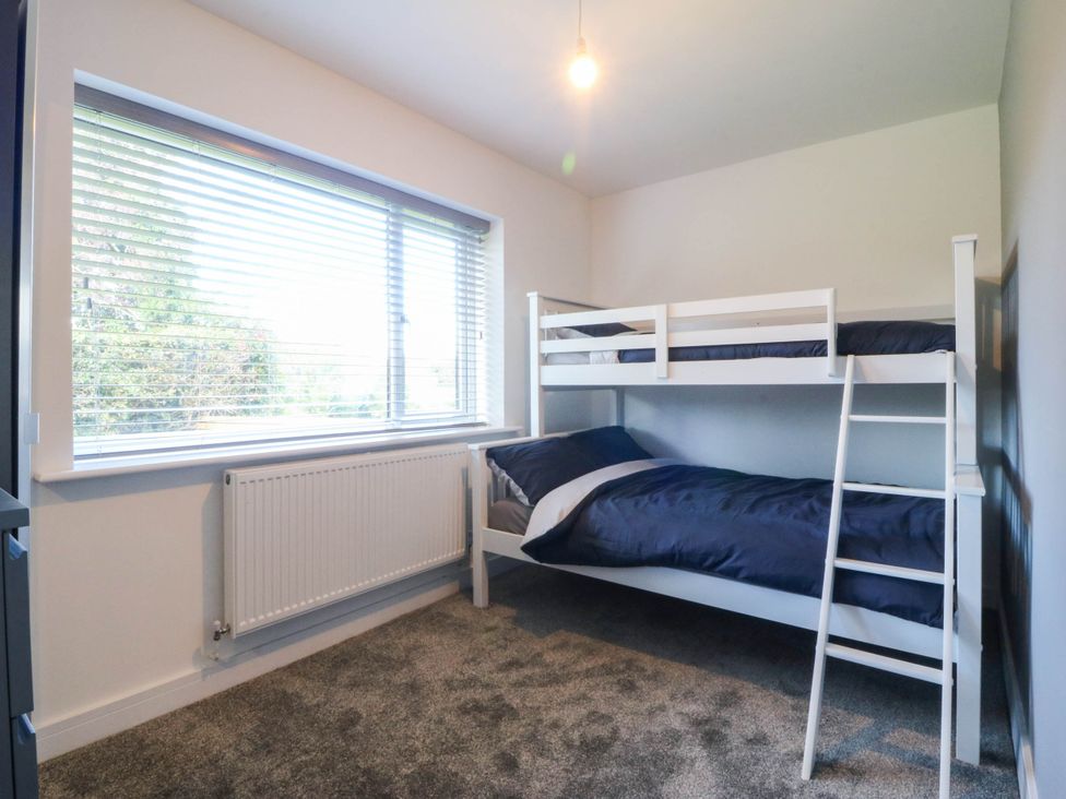 A bedroom with a bunk bed and a window at Angorfa in Pentraeth