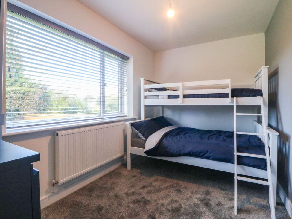 A bedroom with a bunk bed and window at Angorfa in Pentraeth