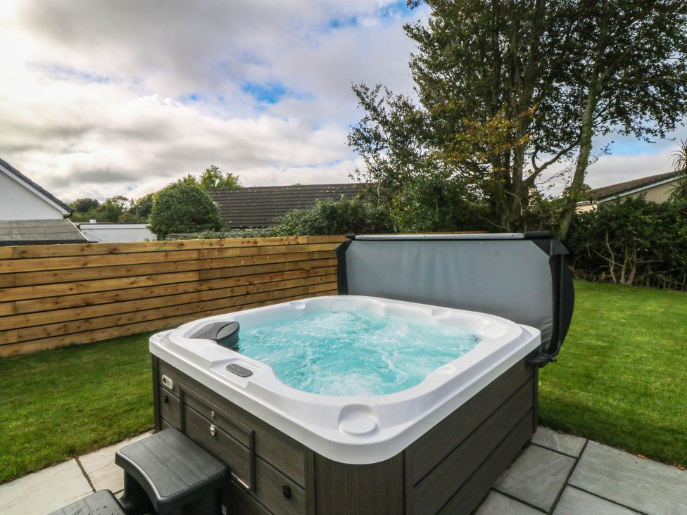 A hot tub with steps in a garden at Angorfa in Pentraeth