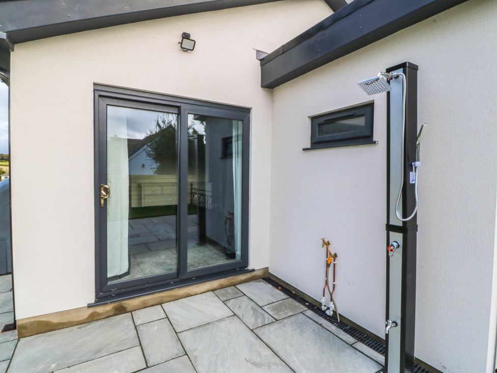 An outdoor shower next to a sliding door at Angorfa in Pentraeth