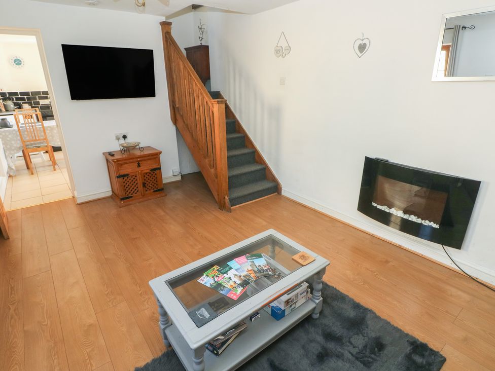 A living room with a coffee table and staircase at Tor Cefn Annex in Kidwelly