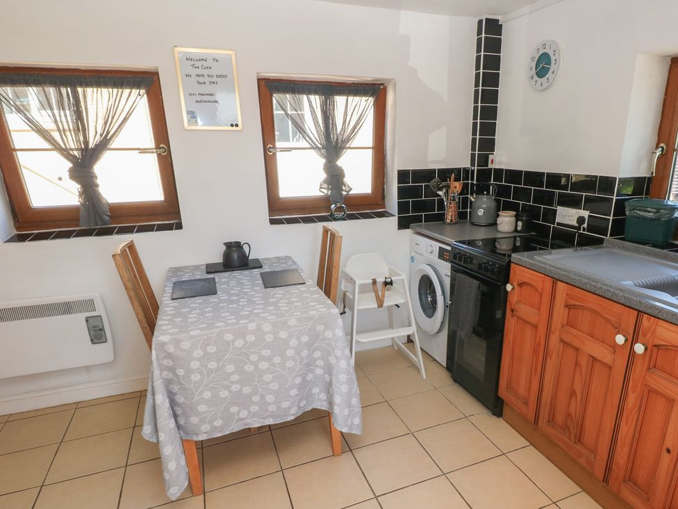 A kitchen with a dining table and appliances at Tor Cefn Annex in Kidwelly