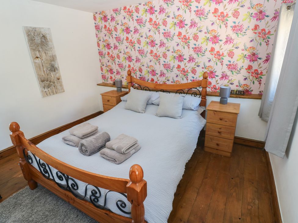 A bedroom with a bed and bedside tables at Tor Cefn Annex Kidwelly