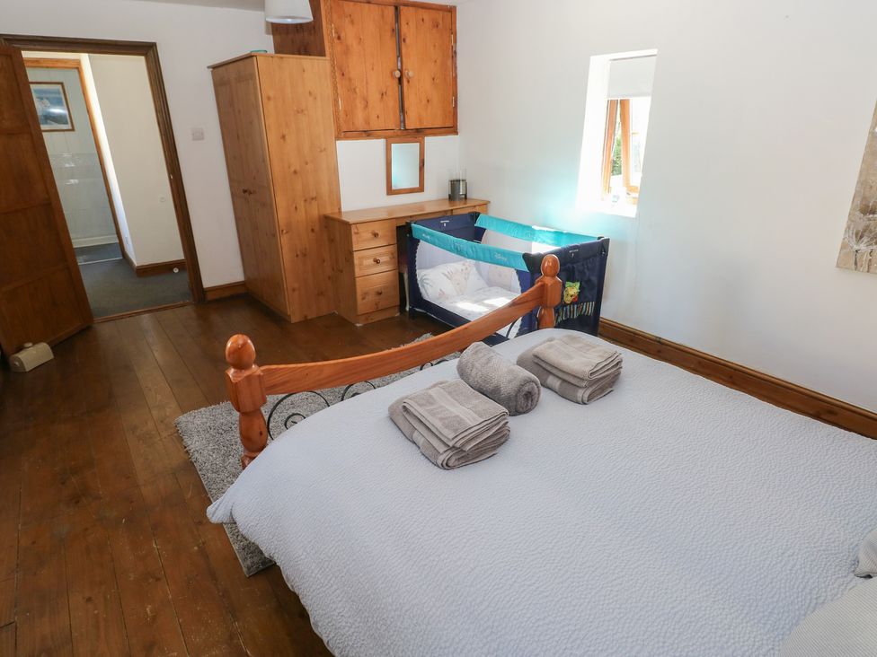 A bedroom with a bed and a crib at Tor Cefn Annex in Kidwelly