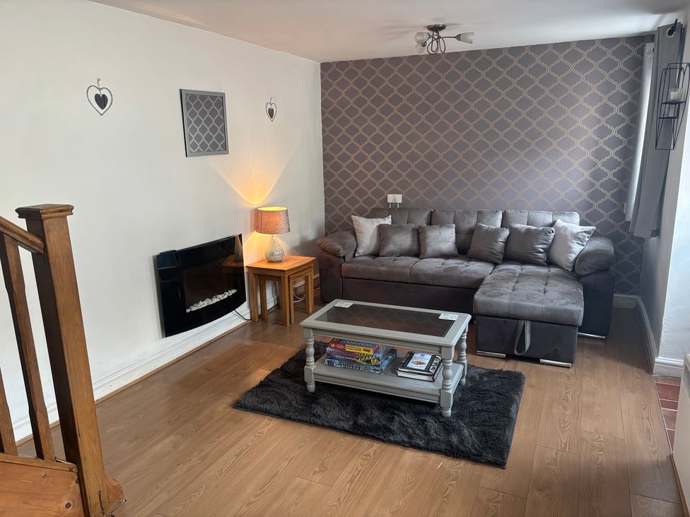 A living room with a sofa and coffee table at Tor Cefn near Pont-Henri
