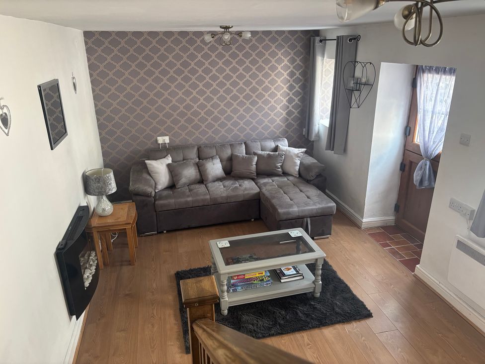 A living room with a sofa and coffee table at Tor Cefn near Pont-Henri