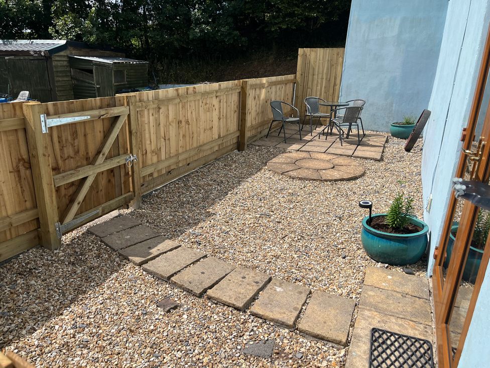 A garden with gravel, a table and chairs at Tor Cefn near Pont-Henri