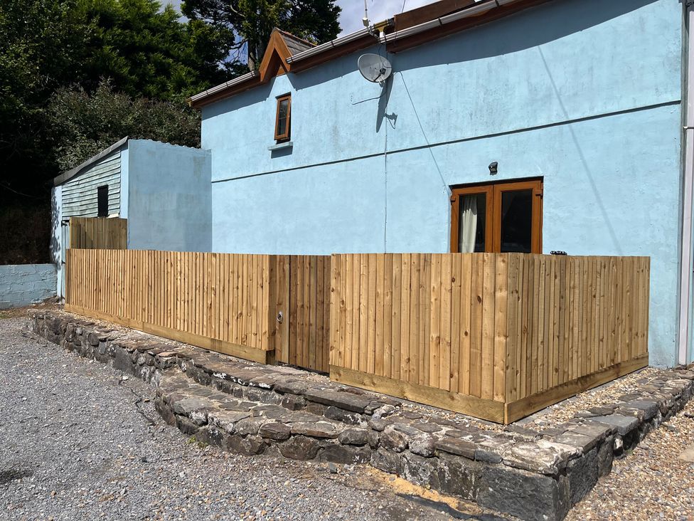 An outdoor area with a wooden fence and patio at Tor Cefn near Pont-Henri
