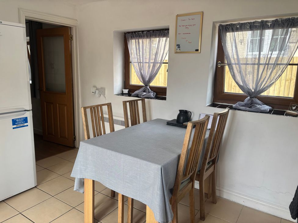 A kitchen with a table and chairs at Tor Cefn near Pont-Henri