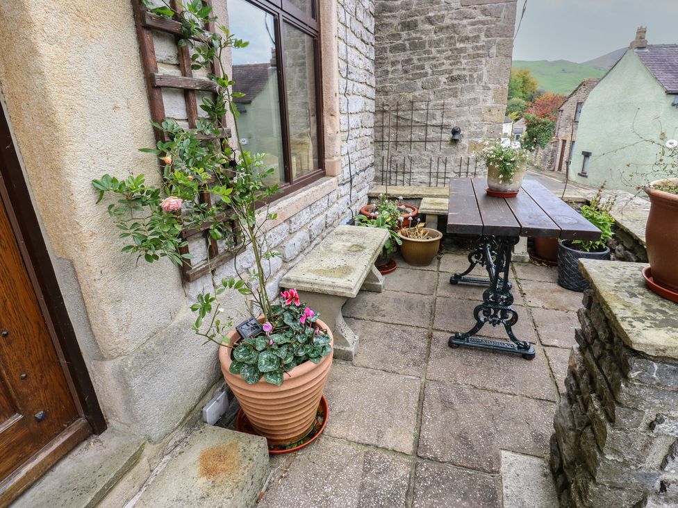 An outdoor patio with a table and plants at Bradshaw House in Hope Valley
