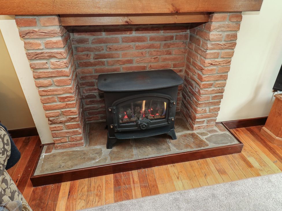 A fireplace with a stove in a living room at Bradshaw House in Hope Valley