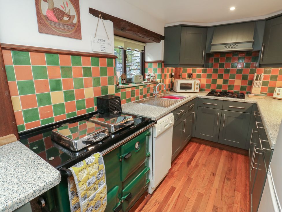 A kitchen with green and orange tiled walls at Bradshaw House in Hope Valley