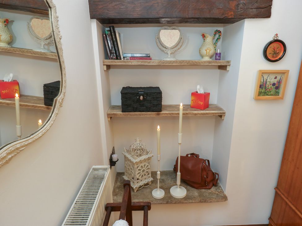 A hallway with shelves holding decorative items at Bradshaw House in Hope Valley